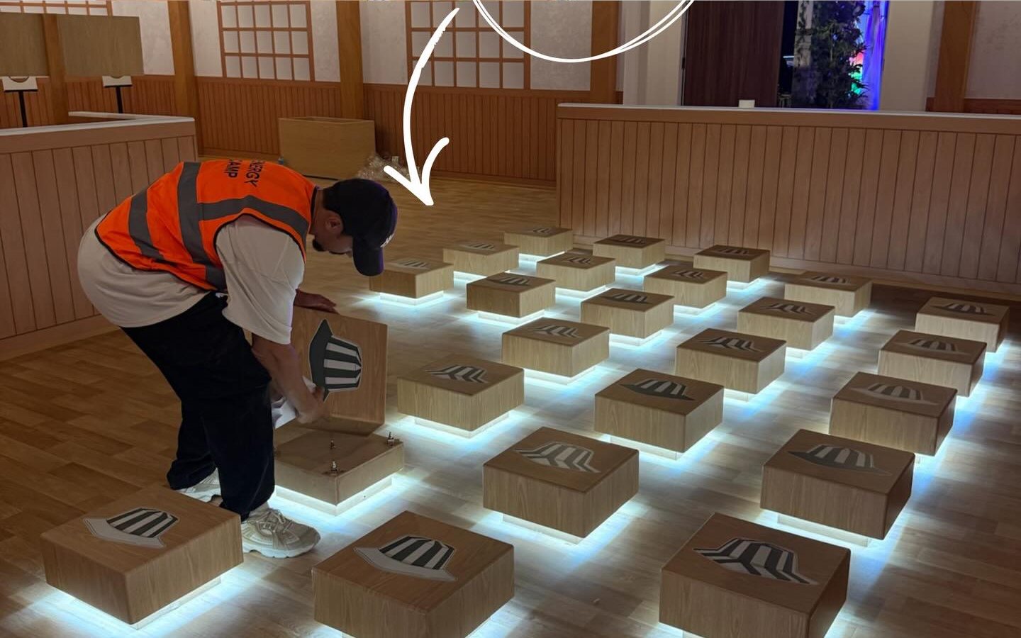 Crew member installing light-up floor tiles